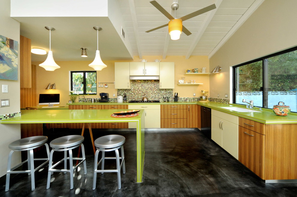 ロサンゼルスにある高級な中くらいなコンテンポラリースタイルのおしゃれなキッチン (アンダーカウンターシンク、フラットパネル扉のキャビネット、中間色木目調キャビネット、クオーツストーンカウンター、マルチカラーのキッチンパネル、モザイクタイルのキッチンパネル、シルバーの調理設備、コンクリートの床、黒い床、緑のキッチンカウンター) の写真