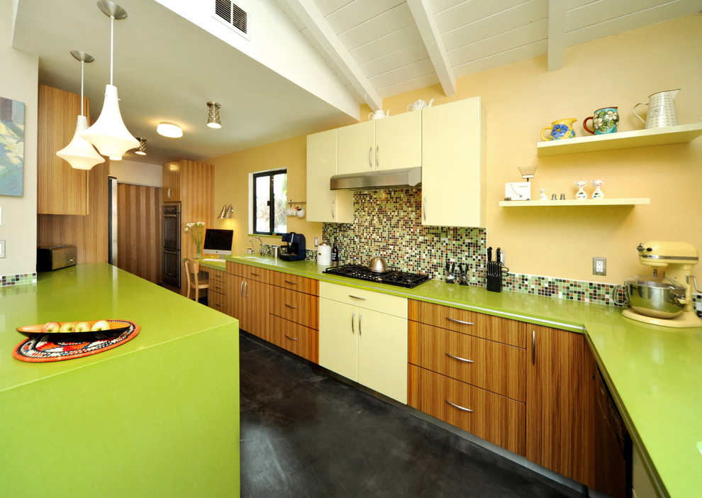Example of a trendy galley concrete floor eat-in kitchen design in Los Angeles with mosaic tile backsplash, flat-panel cabinets, medium tone wood cabinets, multicolored backsplash, quartz countertops, an undermount sink, stainless steel appliances, a peninsula and green countertops