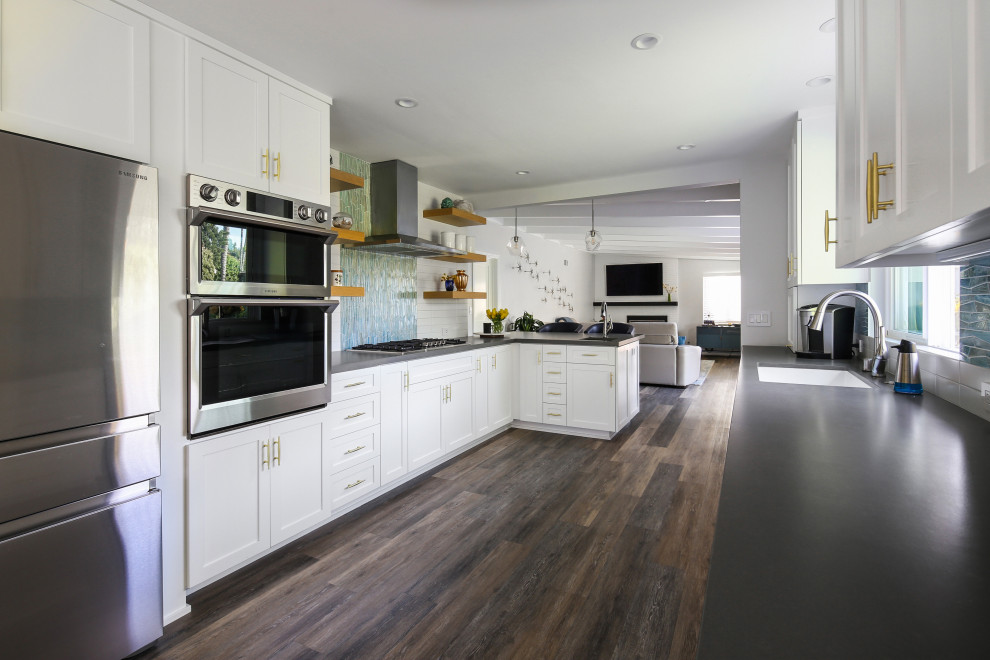 Exempel på ett mellanstort 60 tals grå grått kök och matrum, med en rustik diskho, skåp i shakerstil, vita skåp, vitt stänkskydd, stänkskydd i keramik, rostfria vitvaror, mellanmörkt trägolv, en halv köksö och grått golv