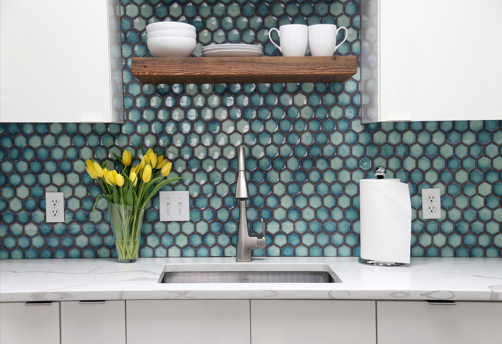 Inspiration for a small 1960s u-shaped ceramic tile and gray floor kitchen remodel in Denver with an undermount sink, flat-panel cabinets, white cabinets, quartzite countertops, blue backsplash, porcelain backsplash, stainless steel appliances and white countertops