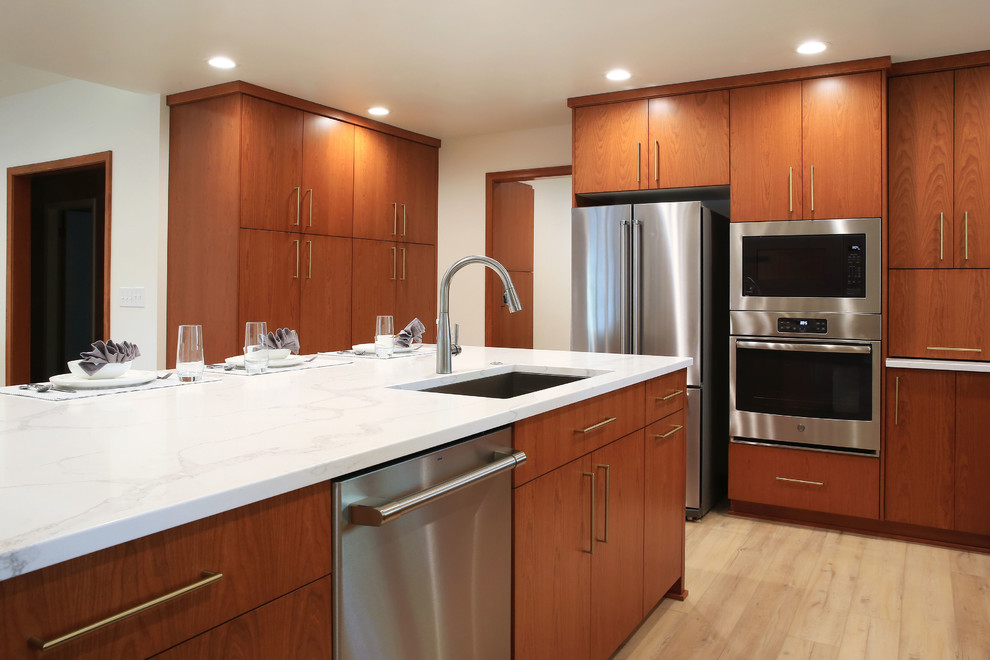 Exempel på ett stort retro vit vitt kök, med en undermonterad diskho, släta luckor, skåp i mellenmörkt trä, bänkskiva i kvarts, vitt stänkskydd, stänkskydd i keramik, rostfria vitvaror, vinylgolv, en köksö och beiget golv