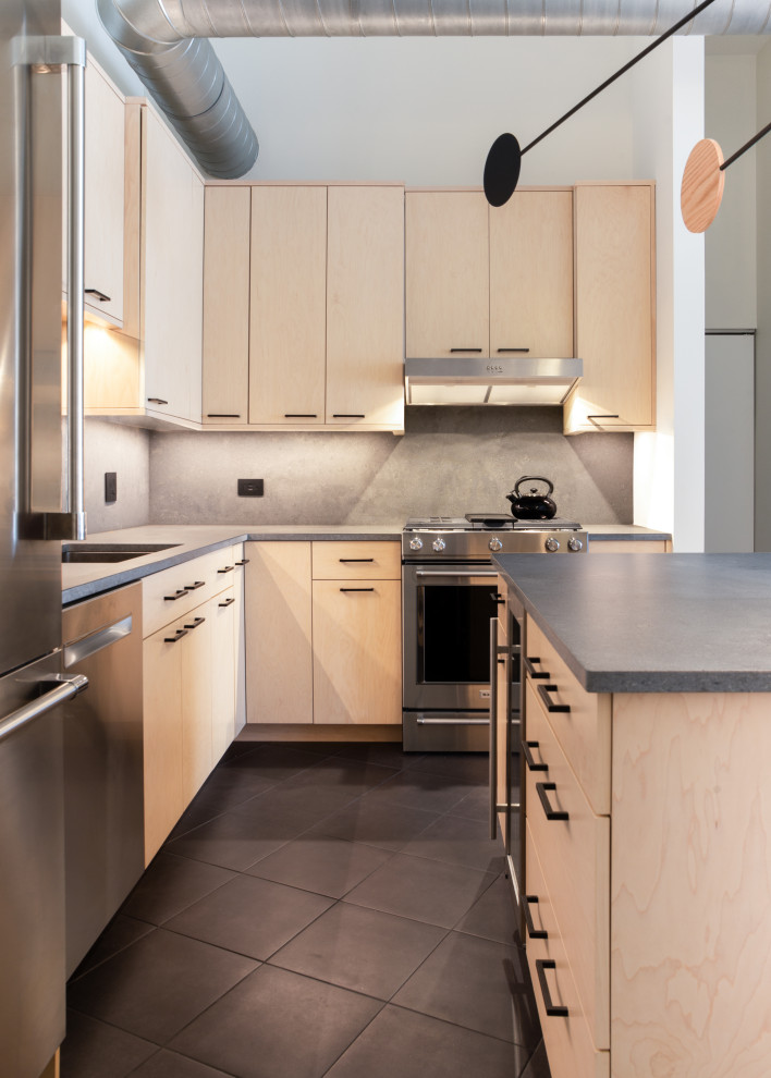 Foto di una cucina design con lavello sottopiano, ante lisce, ante in legno chiaro, paraspruzzi grigio, elettrodomestici in acciaio inossidabile, pavimento nero e top grigio