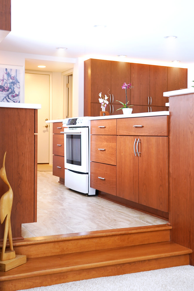 На фото: большая угловая кухня в стиле ретро с обеденным столом, плоскими фасадами, фасадами цвета дерева среднего тона, столешницей из кварцевого агломерата, островом и белой столешницей