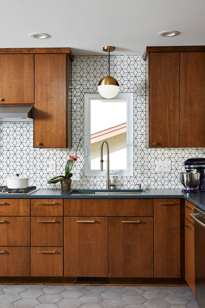 Mid-sized 1950s cement tile floor and gray floor enclosed kitchen photo in Minneapolis with an undermount sink, flat-panel cabinets, medium tone wood cabinets, quartz countertops, white backsplash, cement tile backsplash, stainless steel appliances, no island and black countertops