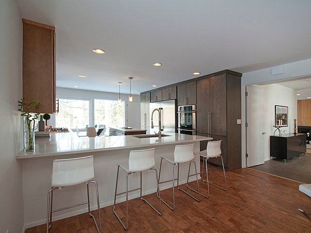 Example of a large 1960s cork floor open concept kitchen design in Detroit with a single-bowl sink, flat-panel cabinets, gray cabinets, quartz countertops, white backsplash, porcelain backsplash and stainless steel appliances