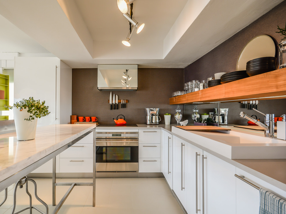 Moderne Küche in L-Form mit integriertem Waschbecken, flächenbündigen Schrankfronten, weißen Schränken, Küchengeräten aus Edelstahl und Kücheninsel in Orlando