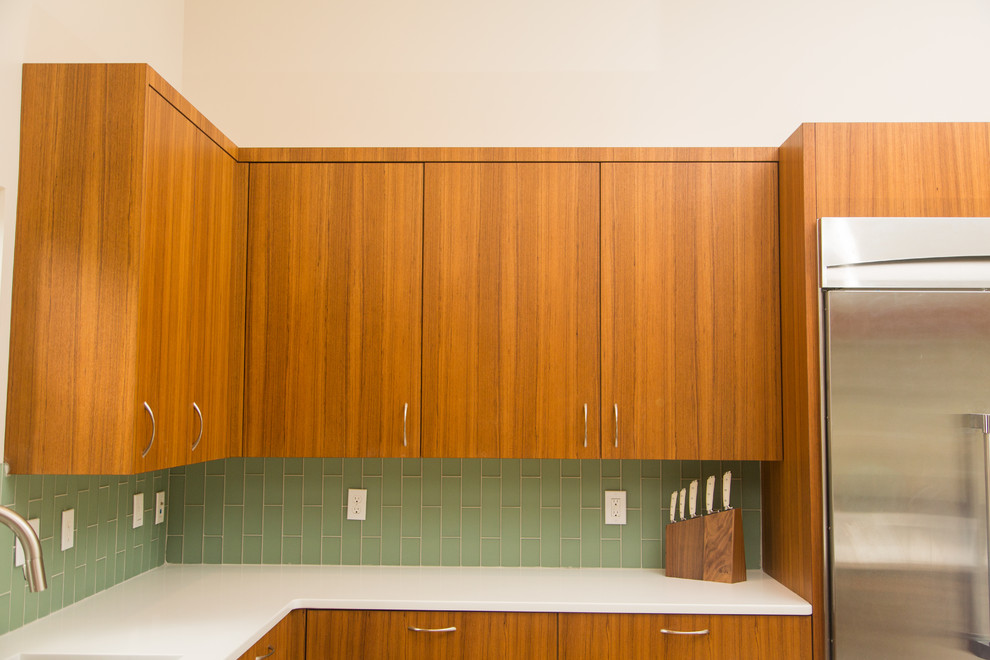 Foto de cocinas en L retro con armarios con paneles lisos, puertas de armario de madera oscura y una isla
