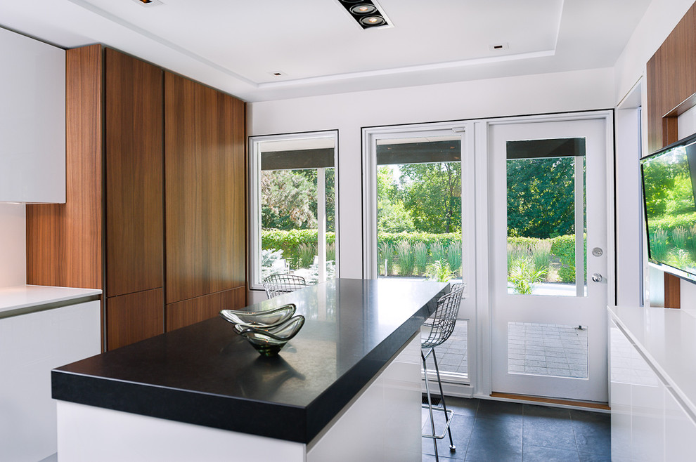 Imagen de cocina actual con armarios con paneles lisos, puertas de armario de madera oscura y salpicadero blanco