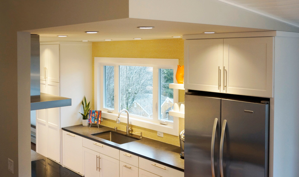 Example of a small 1950s galley open concept kitchen design in Other with an undermount sink, shaker cabinets, white cabinets, quartz countertops, yellow backsplash, ceramic backsplash, stainless steel appliances and a peninsula