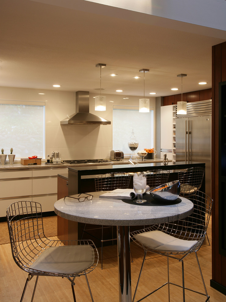 Retro Wohnküche mit flächenbündigen Schrankfronten, weißen Schränken und Küchengeräten aus Edelstahl in Minneapolis