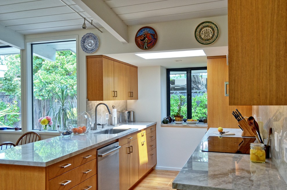 Exempel på ett litet 60 tals vit vitt kök, med en undermonterad diskho, släta luckor, skåp i mellenmörkt trä, stänkskydd i sten, rostfria vitvaror, mellanmörkt trägolv, en halv köksö, brunt golv, granitbänkskiva och vitt stänkskydd