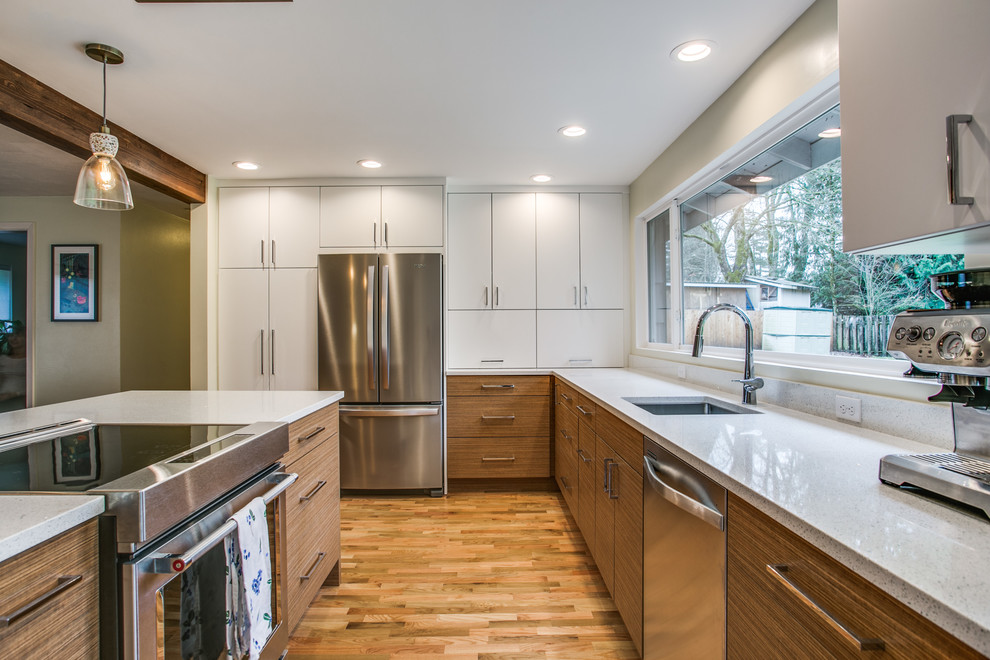 Design ideas for a medium sized retro l-shaped open plan kitchen in Seattle with a submerged sink, flat-panel cabinets, white cabinets, quartz worktops, white splashback, stainless steel appliances, medium hardwood flooring, an island and brown floors.