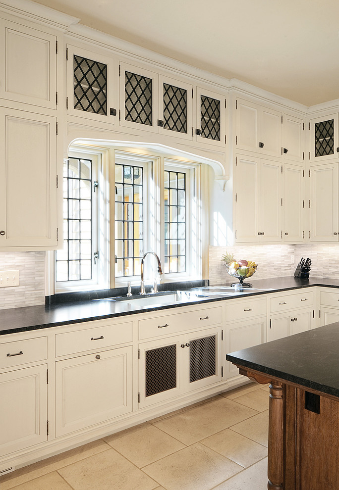 Idéer för att renovera ett mycket stort vintage kök, med luckor med infälld panel, vita skåp, granitbänkskiva, grått stänkskydd, stänkskydd i mosaik, kalkstensgolv, en köksö och beiget golv