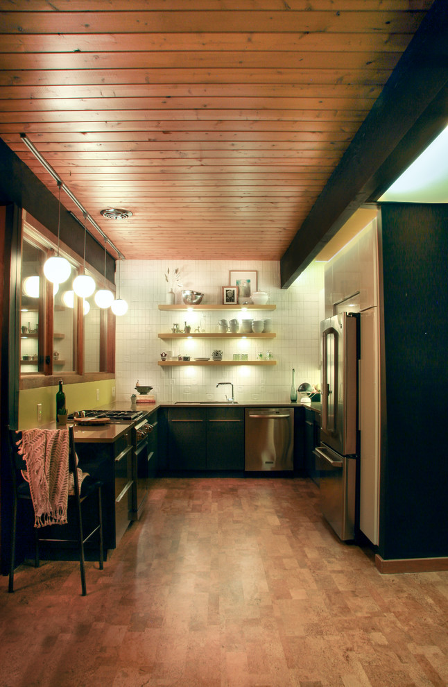 Exempel på ett 60 tals kök, med en undermonterad diskho, släta luckor, grå skåp, bänkskiva i koppar, vitt stänkskydd, stänkskydd i keramik, rostfria vitvaror och korkgolv