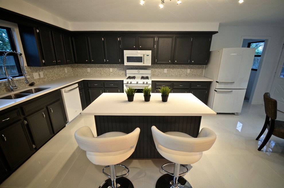 Idéer för ett modernt l-kök, med en dubbel diskho, grå skåp, bänkskiva i kvarts, stänkskydd i mosaik, vita vitvaror, klinkergolv i porslin och en köksö