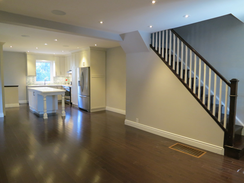 Example of a mid-sized trendy u-shaped dark wood floor open concept kitchen design in Toronto with an undermount sink, shaker cabinets, gray cabinets, quartz countertops, multicolored backsplash, stainless steel appliances and an island