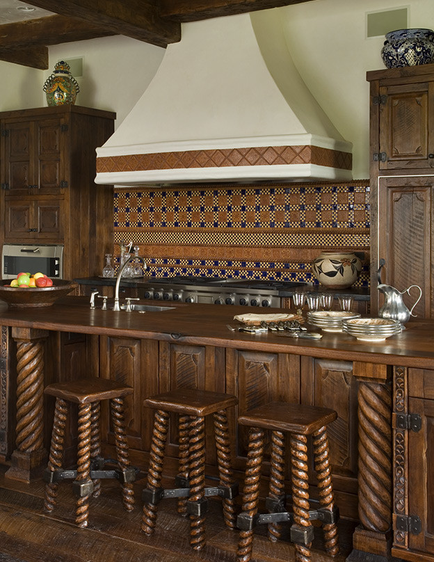 Aménagement d'une grande cuisine américaine montagne avec un placard avec porte à panneau surélevé, un plan de travail en bois, une crédence en mosaïque, un électroménager en acier inoxydable, un sol en bois brun et îlot.