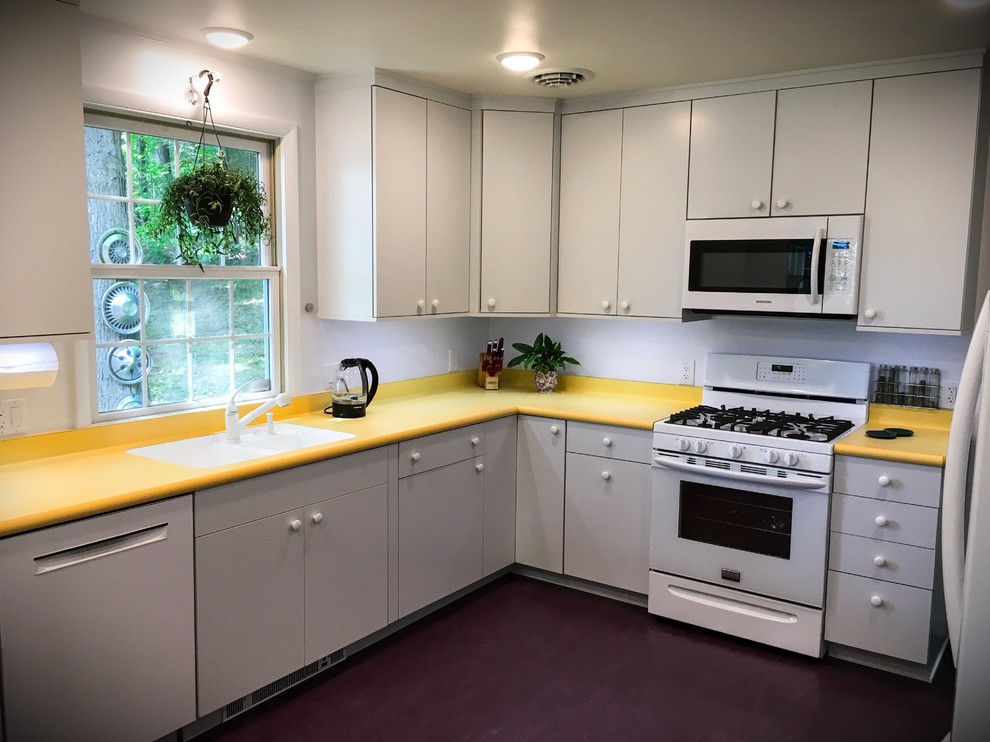 Foto på ett avskilt, mellanstort retro u-kök, med en undermonterad diskho, släta luckor, vita skåp, laminatbänkskiva, vitt stänkskydd, vita vitvaror, linoleumgolv och lila golv