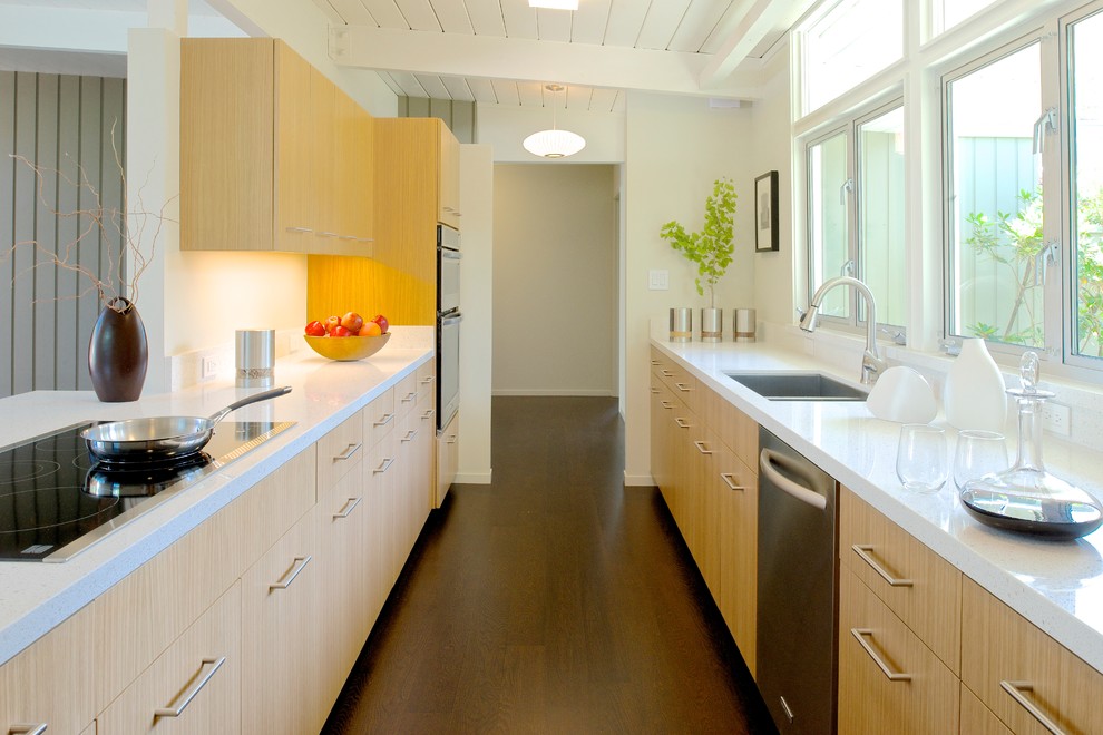 Ejemplo de cocina retro de tamaño medio con fregadero bajoencimera, armarios con paneles lisos, puertas de armario de madera clara y suelo de madera oscura