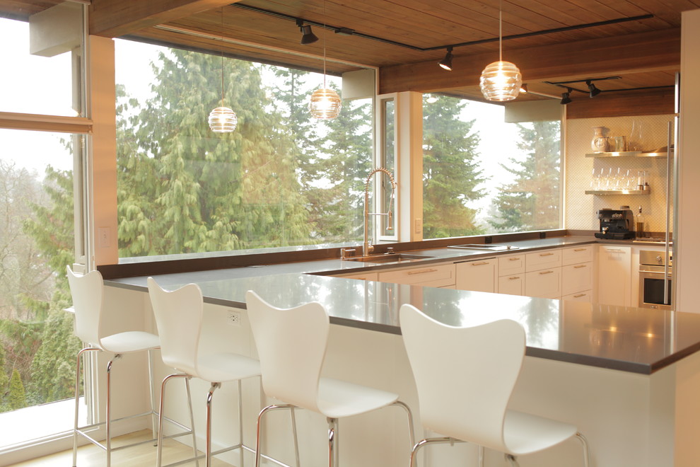 Example of a mid-century modern u-shaped light wood floor open concept kitchen design in Seattle with an undermount sink, shaker cabinets, white cabinets, quartz countertops, gray backsplash and stainless steel appliances