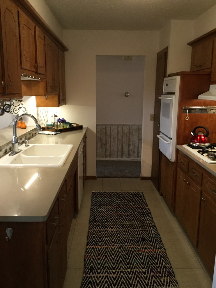 Cette image montre une cuisine américaine parallèle vintage en bois brun avec un évier 2 bacs, un plan de travail en quartz, une crédence multicolore et une crédence en mosaïque.