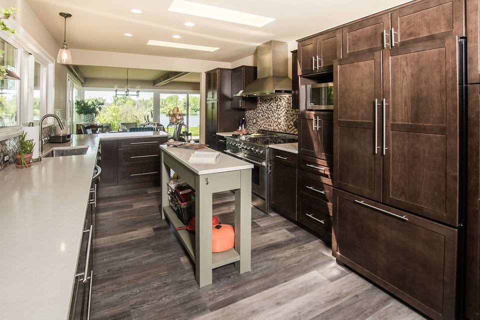 Large 1950s porcelain tile and brown floor kitchen photo in Detroit with an undermount sink, recessed-panel cabinets, dark wood cabinets, quartz countertops, multicolored backsplash, mosaic tile backsplash, stainless steel appliances and an island