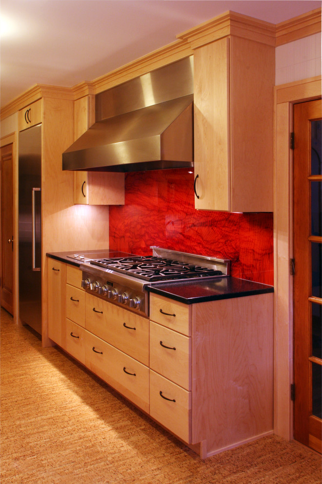 Exempel på ett avskilt, stort modernt u-kök, med släta luckor, skåp i ljust trä, rostfria vitvaror, korkgolv, bänkskiva i kvarts, rött stänkskydd och stänkskydd i sten