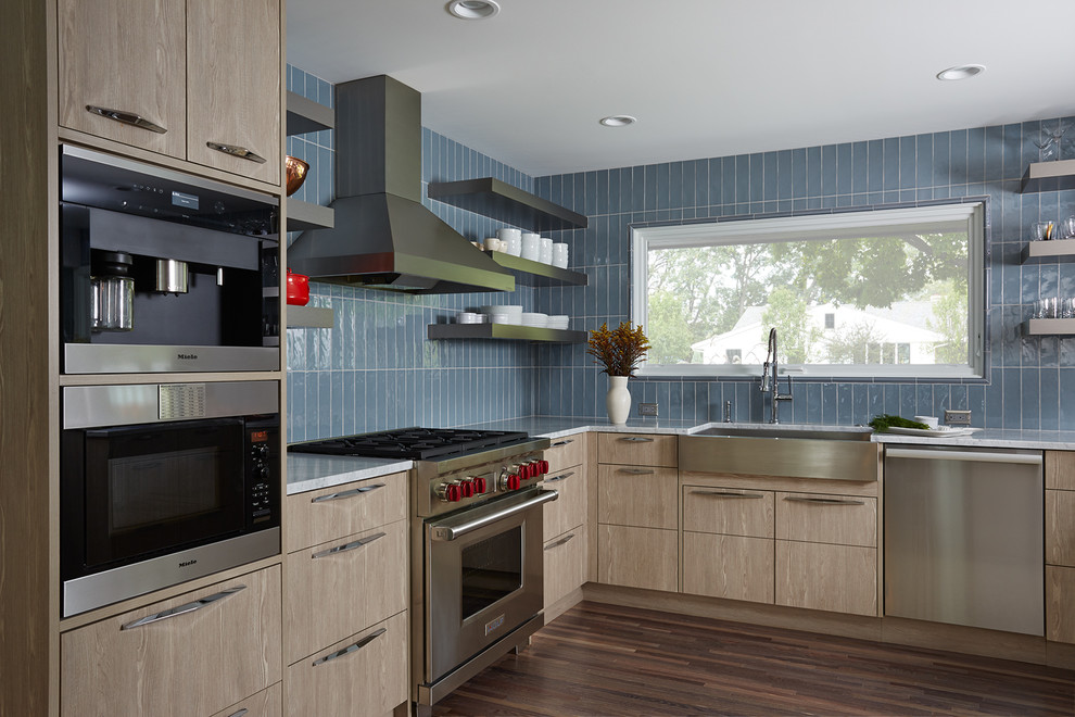 Mittelgroße Moderne Küche ohne Insel in L-Form mit Landhausspüle, flächenbündigen Schrankfronten, Küchenrückwand in Blau, Küchengeräten aus Edelstahl, dunklem Holzboden und hellbraunen Holzschränken in Minneapolis