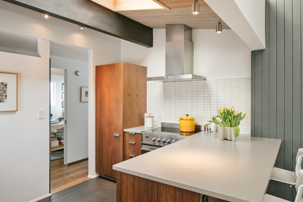 Small midcentury l-shaped kitchen in Seattle with a submerged sink, flat-panel cabinets, medium wood cabinets, engineered stone countertops, white splashback, ceramic splashback, integrated appliances, ceramic flooring, no island, grey floors and grey worktops.