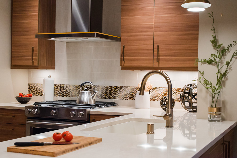 Photo of a medium sized retro l-shaped enclosed kitchen in Minneapolis with a submerged sink, flat-panel cabinets, medium wood cabinets, engineered stone countertops, grey splashback, metro tiled splashback, stainless steel appliances and a breakfast bar.
