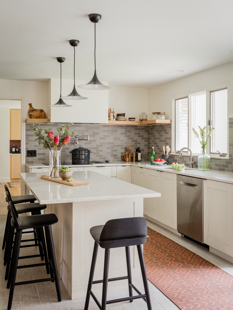 Moderne Küche in L-Form mit Unterbauwaschbecken, Schrankfronten im Shaker-Stil, weißen Schränken, Küchenrückwand in Grau, Küchengeräten aus Edelstahl, Kücheninsel, grauem Boden und weißer Arbeitsplatte in Boston