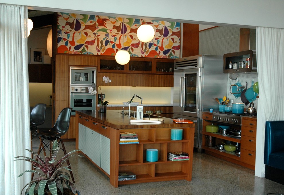 Example of a 1950s l-shaped kitchen design in Santa Barbara with flat-panel cabinets, medium tone wood cabinets, wood countertops and stainless steel appliances