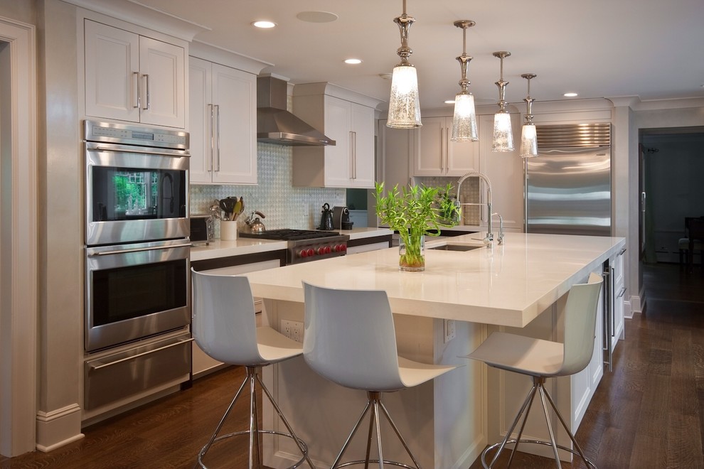 Inspiration for a large contemporary l-shaped dark wood floor open concept kitchen remodel in New York with a double-bowl sink, shaker cabinets, white cabinets, quartz countertops, blue backsplash, mosaic tile backsplash, stainless steel appliances and an island