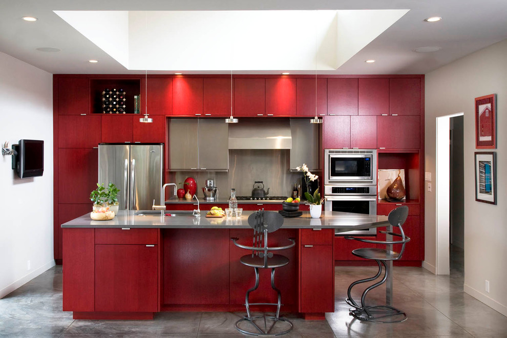 Example of a trendy galley enclosed kitchen design in Albuquerque with an undermount sink, flat-panel cabinets, red cabinets, metallic backsplash and stainless steel appliances