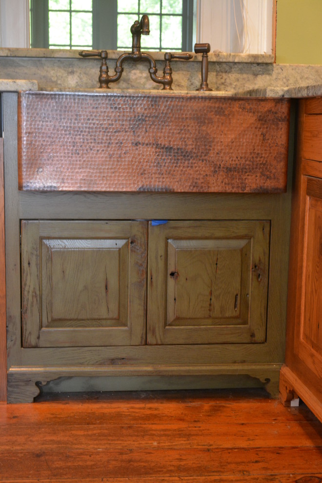 Idéer för ett mellanstort lantligt kök, med en rustik diskho, luckor med upphöjd panel, skåp i mellenmörkt trä, granitbänkskiva, grönt stänkskydd, rostfria vitvaror, mellanmörkt trägolv och en halv köksö