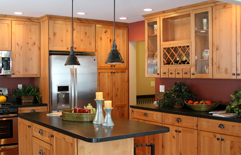 Foto på ett mellanstort amerikanskt kök, med en undermonterad diskho, skåp i shakerstil, skåp i mellenmörkt trä, bänkskiva i koppar, svart stänkskydd, rostfria vitvaror, mellanmörkt trägolv och en köksö