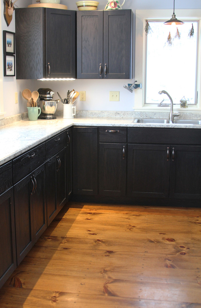 Small minimalist u-shaped light wood floor eat-in kitchen photo in Burlington with a double-bowl sink, shaker cabinets, black cabinets, laminate countertops, gray backsplash, stainless steel appliances and a peninsula
