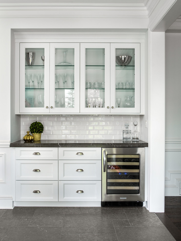 Foto de cocina clásica con armarios tipo vitrina, puertas de armario blancas, salpicadero blanco, salpicadero de azulejos tipo metro y electrodomésticos de acero inoxidable
