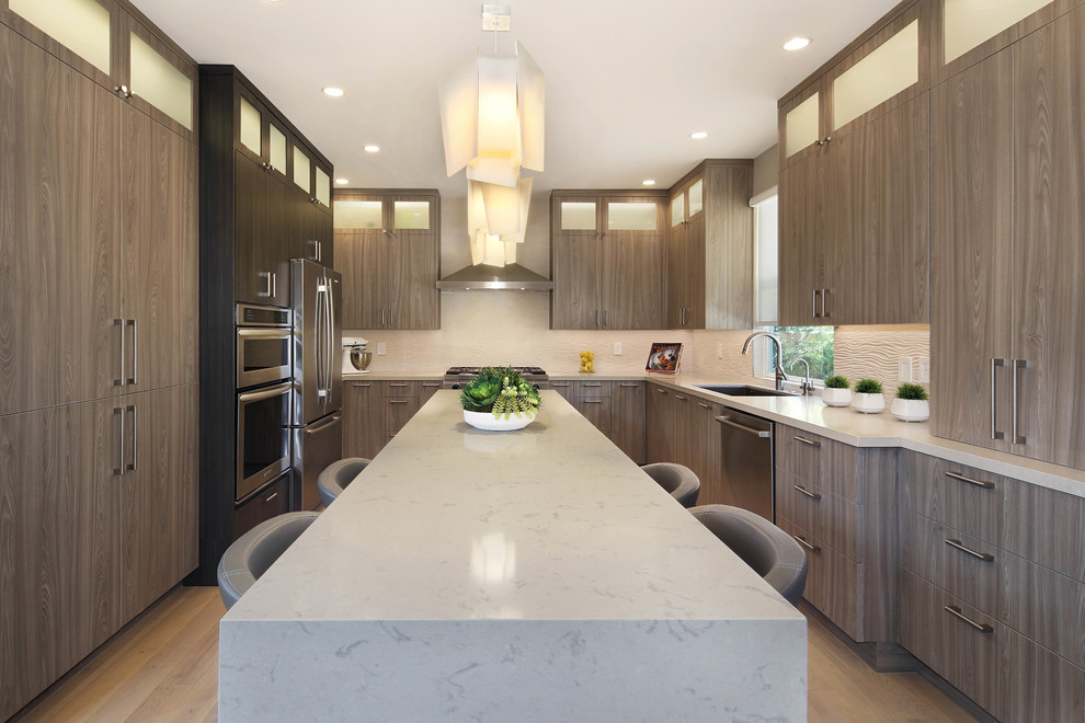 Eat-in kitchen - mid-sized contemporary u-shaped light wood floor and beige floor eat-in kitchen idea in Orange County with an undermount sink, flat-panel cabinets, quartz countertops, porcelain backsplash, stainless steel appliances, an island, white countertops, medium tone wood cabinets and beige backsplash