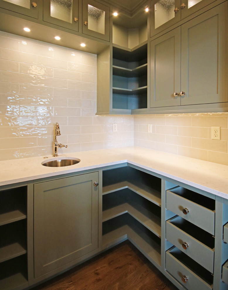 This is an example of a traditional kitchen pantry in Orange County with a submerged sink, open cabinets, green cabinets, engineered stone countertops, white splashback and dark hardwood flooring.