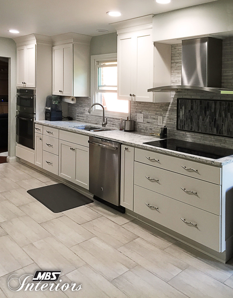 Exempel på ett stort klassiskt linjärt kök och matrum, med en undermonterad diskho, skåp i shakerstil, vita skåp, bänkskiva i kvarts, grått stänkskydd, stänkskydd i keramik, rostfria vitvaror, en köksö, klinkergolv i keramik och grått golv