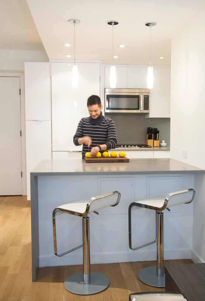 Foto på ett litet funkis kök med öppen planlösning, med släta luckor, vita skåp, bänkskiva i koppar, grått stänkskydd, rostfria vitvaror och en köksö