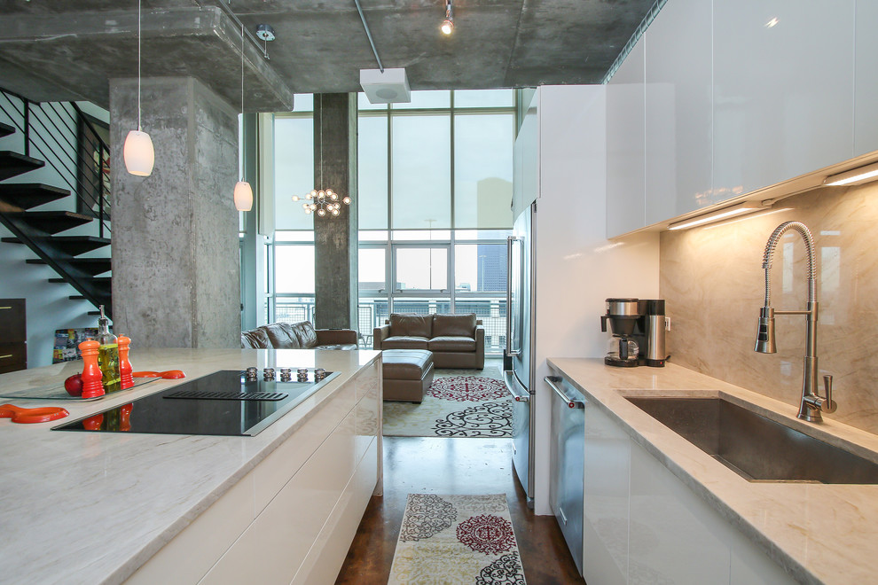 Bild på ett litet funkis linjärt kök, med en undermonterad diskho, släta luckor, vita skåp, bänkskiva i kvarts, vitt stänkskydd, stänkskydd i sten, rostfria vitvaror, betonggolv, en köksö och brunt golv