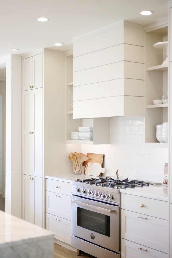 Inspiration for a large contemporary l-shaped light wood floor open concept kitchen remodel in Other with an undermount sink, shaker cabinets, white cabinets, marble countertops, white backsplash, subway tile backsplash, stainless steel appliances and an island