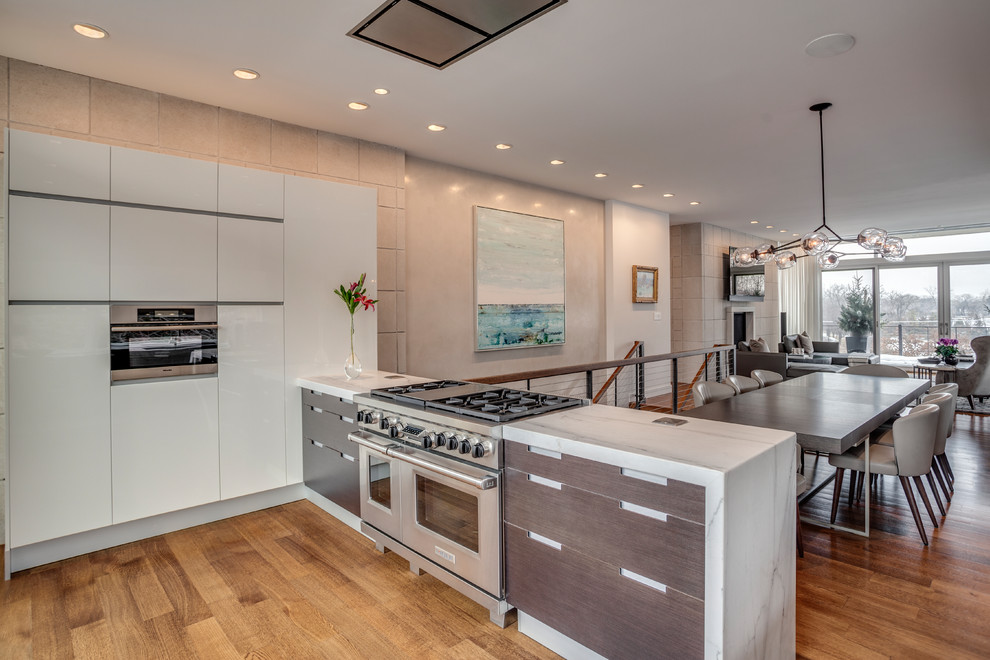Foto di una cucina contemporanea con top in marmo, elettrodomestici in acciaio inossidabile, pavimento in legno massello medio e pavimento marrone