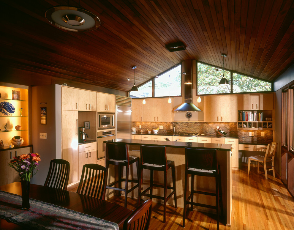 Пример оригинального дизайна: угловая кухня в стиле ретро с обеденным столом, накладной мойкой, плоскими фасадами, светлыми деревянными фасадами, фартуком из плитки мозаики и техникой из нержавеющей стали