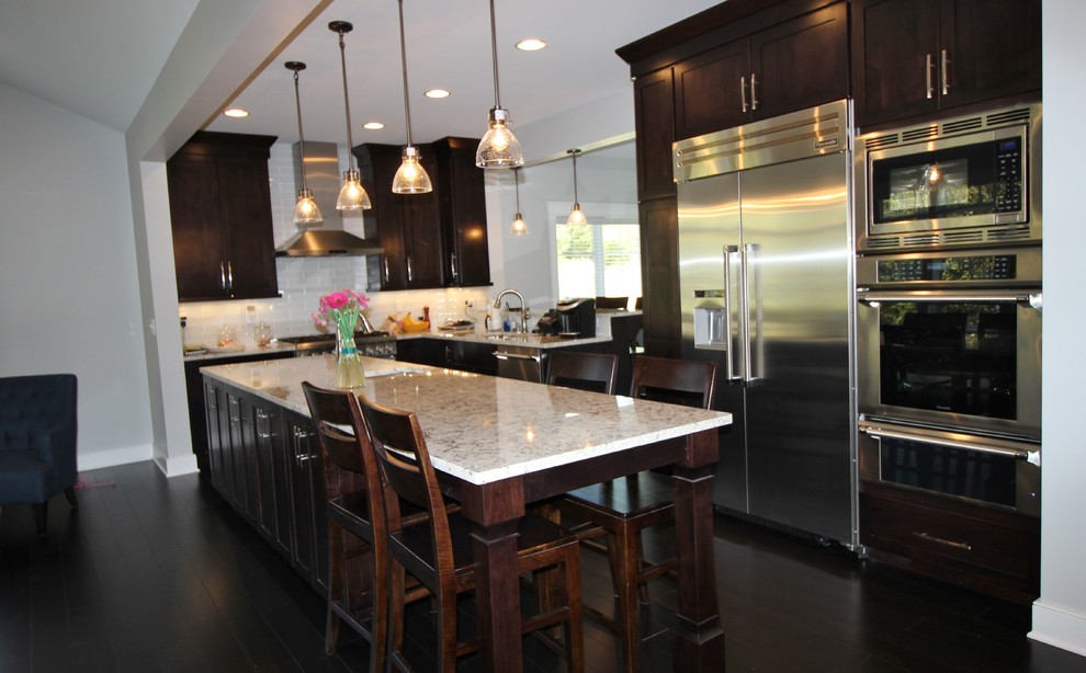 Eat-in kitchen - mid-sized traditional galley dark wood floor eat-in kitchen idea in Other with an undermount sink, dark wood cabinets, granite countertops, white backsplash, porcelain backsplash, stainless steel appliances and an island