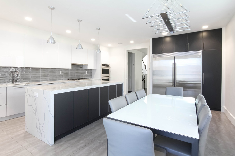 Large minimalist l-shaped ceramic tile and multicolored floor eat-in kitchen photo in New York with an undermount sink, flat-panel cabinets, white cabinets, granite countertops, gray backsplash, glass tile backsplash, stainless steel appliances, an island and white countertops