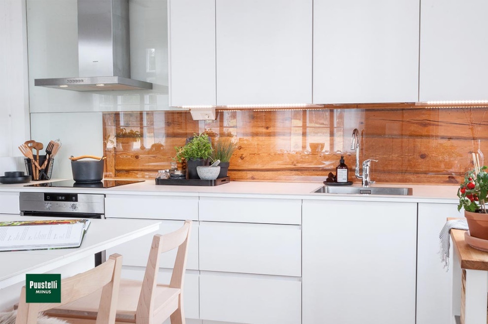 This is an example of a small modern single-wall kitchen/diner in Cheshire with a built-in sink, flat-panel cabinets, white cabinets, engineered stone countertops, brown splashback, glass sheet splashback, black appliances, an island and white worktops.