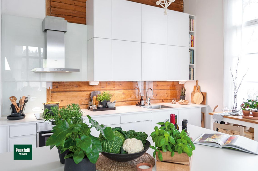 Exempel på ett litet modernt vit linjärt vitt kök och matrum, med en nedsänkt diskho, släta luckor, vita skåp, bänkskiva i kvarts, brunt stänkskydd, glaspanel som stänkskydd, svarta vitvaror och en köksö